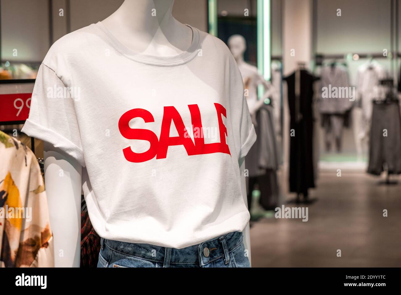 Maniquí con una camiseta blanca con un signo rojo de venta en el fondo de  una tienda de ropa. Promoción, publicidad, compras y el viernes negro  conceps Fotografía de stock - Alamy