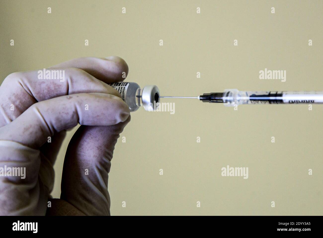 el trabajador de salud inhala con una jeringa la vacuna para ser administrada a un colega. Día de la vacuna en Italia, las primeras inyecciones de la vacuna Pfizer se administran a los trabajadores de la salud al mismo tiempo. Foto de stock