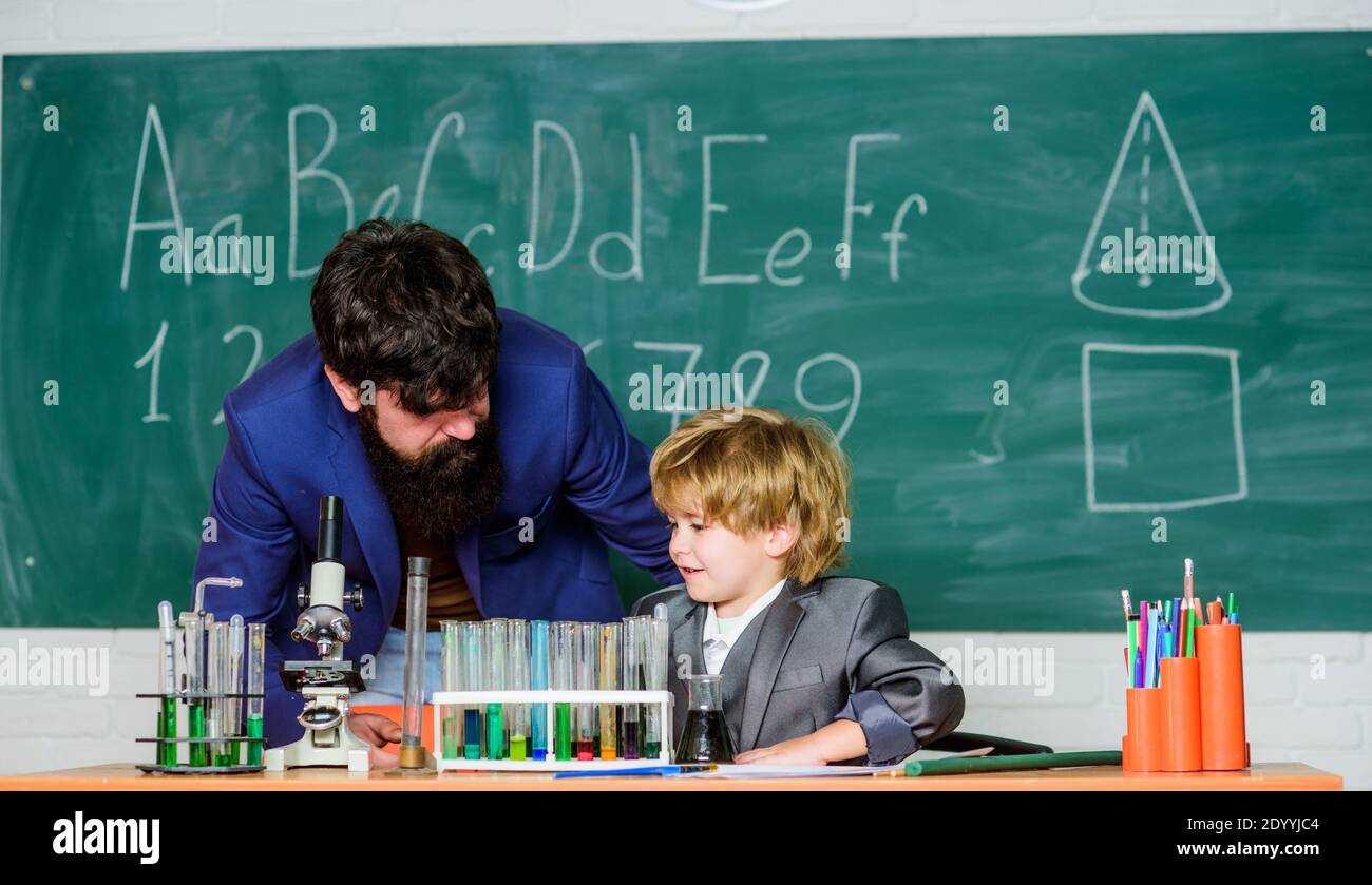 Mi padre es científico. El maestro barbudo hombre padre y el niño tubos de  prueba. Estudie la química juntos. Solo chicos. Ejemplo personal.  Experimento químico. Seguir a padre en todo. Día del