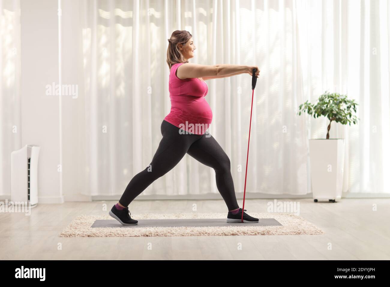 Mujer embarazada haciendo ejercicios de pilates con una banda