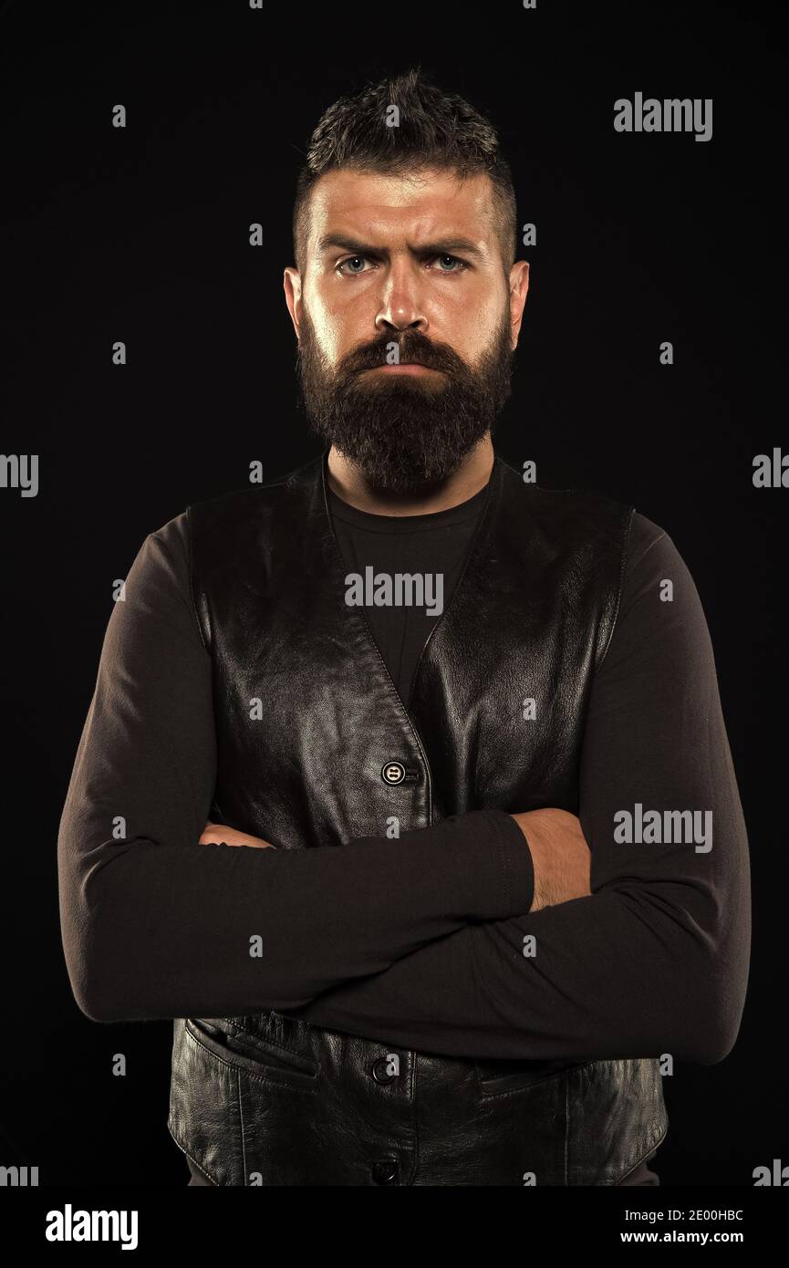 Cara madura estricta. Cabello facial. Cara macho. Cara guapa. Hombre con  barba en ropa de cuero negro. Hombre seguro y brutal estilo negro de fondo.  Concepto de peluquería de barbería. Crece el
