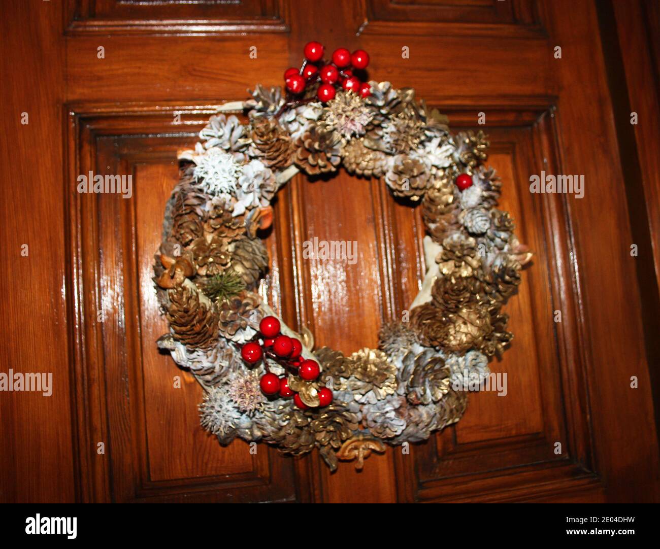 Coronas tejidas con coronas navideñas y otras colgantes En una puerta de un hogar para Navidad Fotografía de stock - Alamy