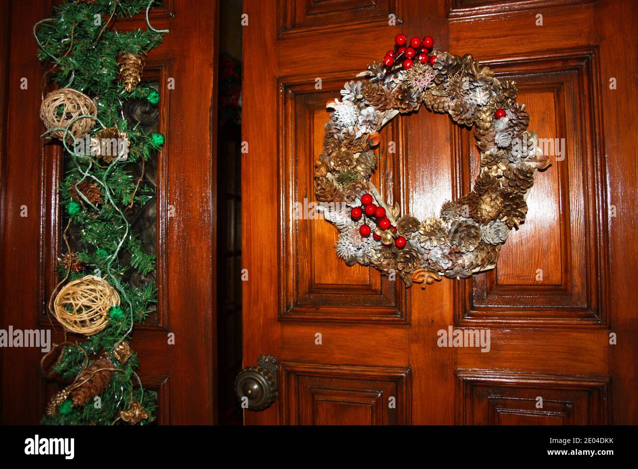 Coronas románticas tejidas con coronas navideñas y otras decoraciones  colgantes En una puerta de un hogar acogedor para Navidad Fotografía de  stock - Alamy