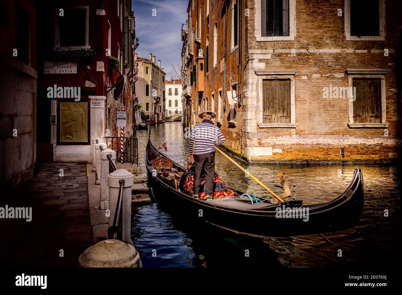 Gondalier en Venecia Italia sobre un canal Foto de stock