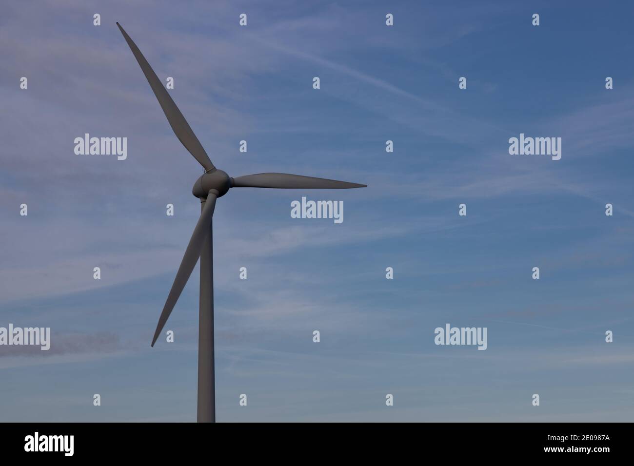 Detalle de un aerogenerador con un hermoso cielo en el fondo que simboliza la energía renovable y limpia Foto de stock