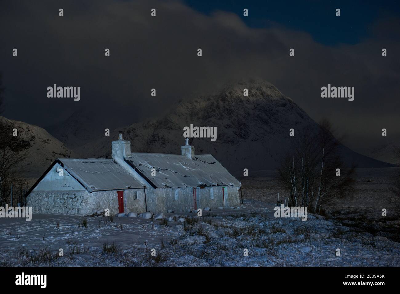 Glencoe, Escocia, Reino Unido. 30 de diciembre de 2020. Foto: Highland Cottage en Glencoe con la famosa montaña triangular de Buachaille Etive Mòr en el fondo con su cumbre envuelta en nubes y niebla helada. La nieve amarilla advierte en su lugar como más nieve con temperaturas de congelación se espera de nuevo durante la noche. Crédito: Colin Fisher/Alamy Live News Foto de stock