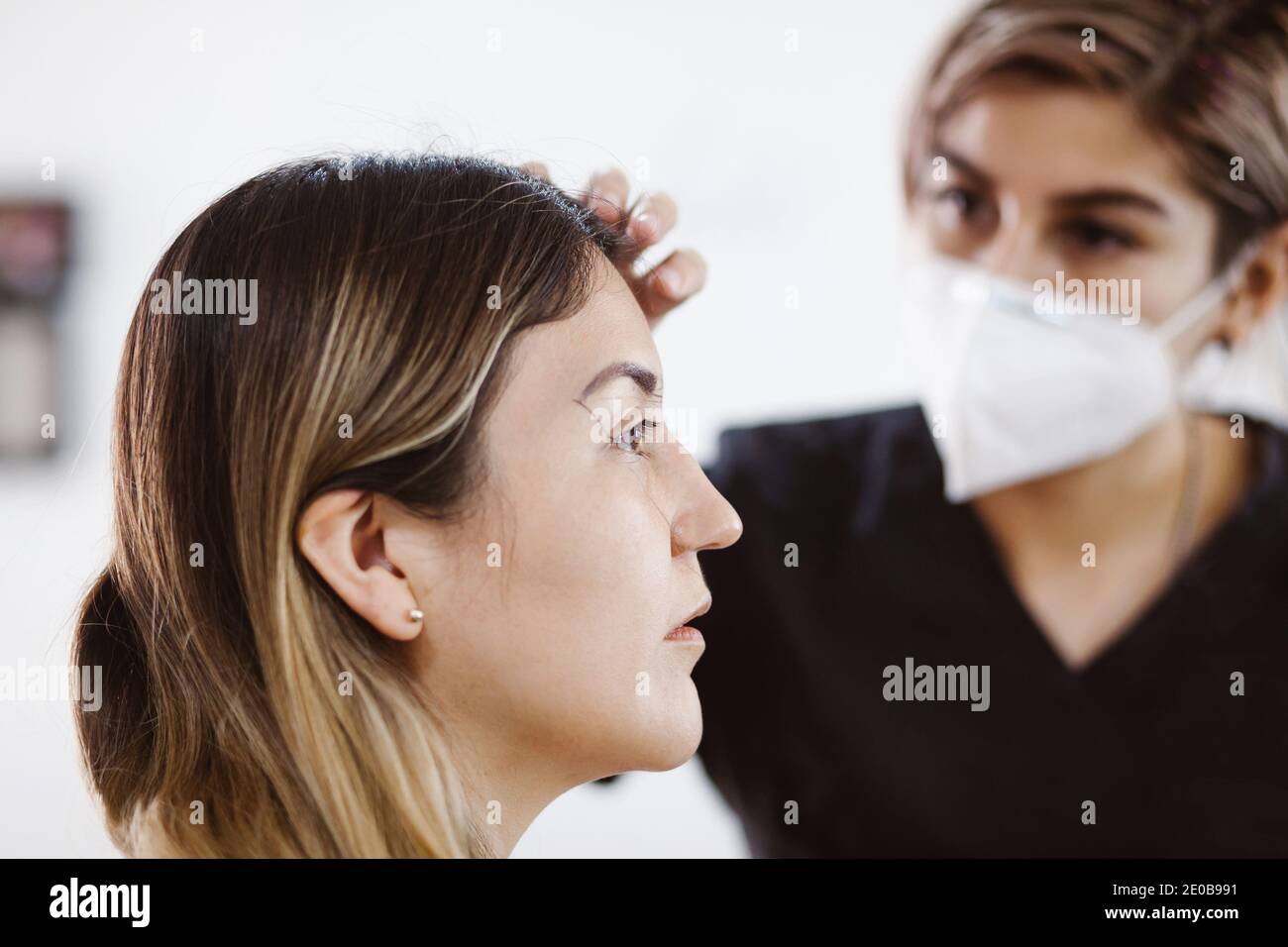 Cosmetólogo Latino preparándose a la mujer mexicana para el procedimiento  de maquillaje permanente de cejas en México, microblading closeup  Fotografía de stock - Alamy