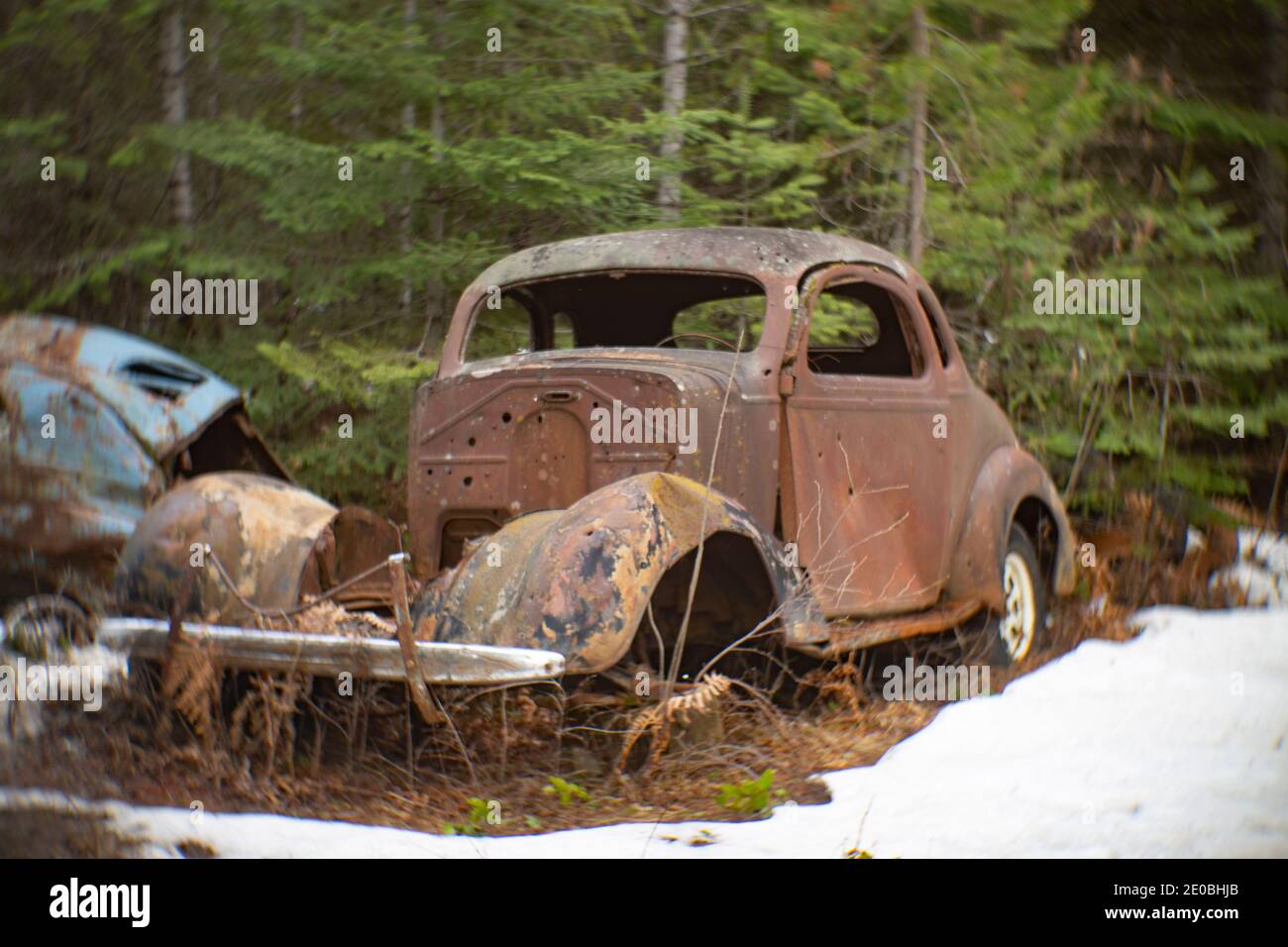 Un oxidado Chevrolet 1937 2 puertas Coupé, en una zona boscosa, en Noxon, Montana esta imagen fue tomada con una antigua lente Petzval y mostrará signos de dis Foto de stock