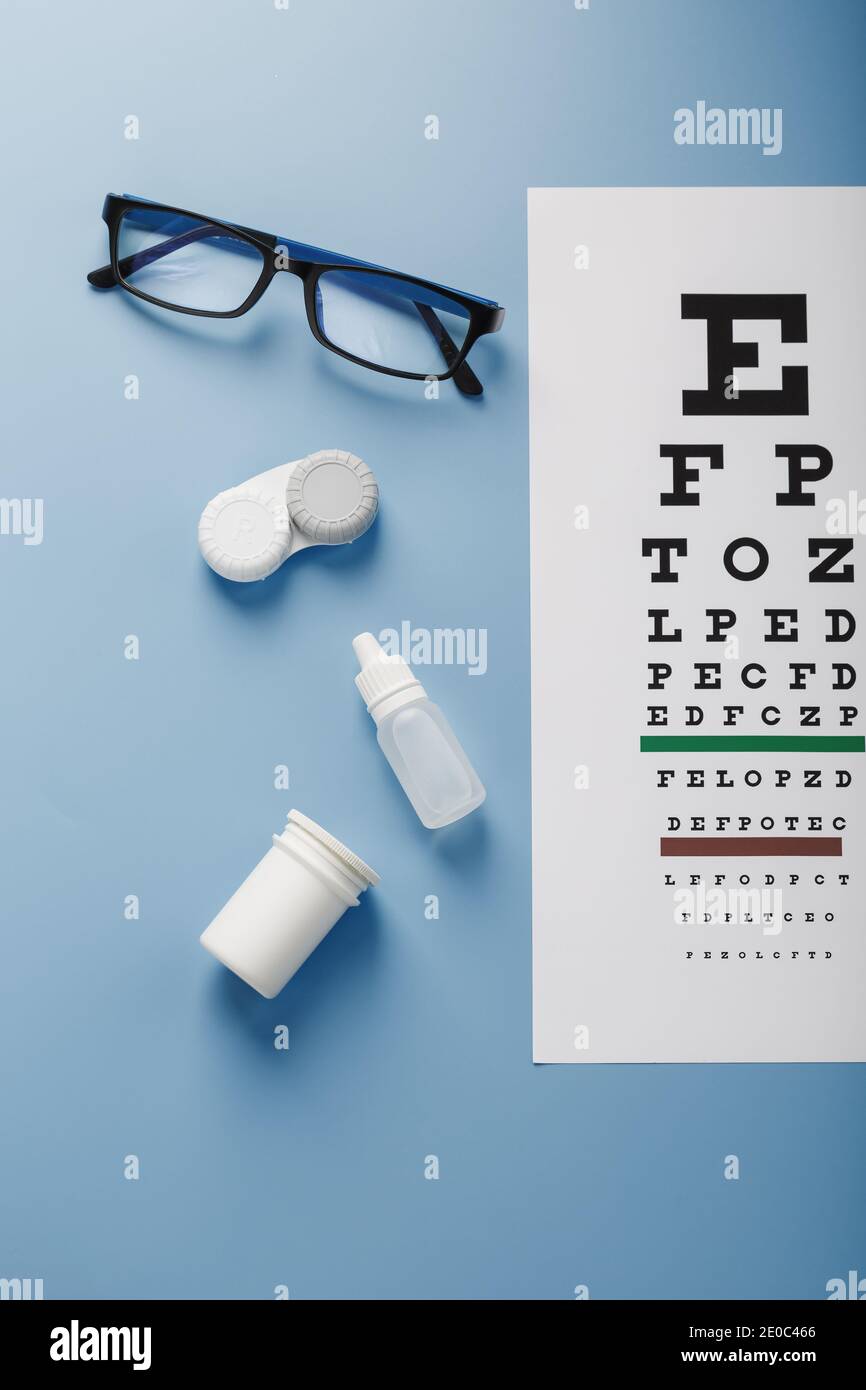 Gafas con lentes de contacto, gotas y un cuadro de examen ocular de  optometrista sobre fondo azul. La vista desde arriba. Espacio libre  Fotografía de stock - Alamy