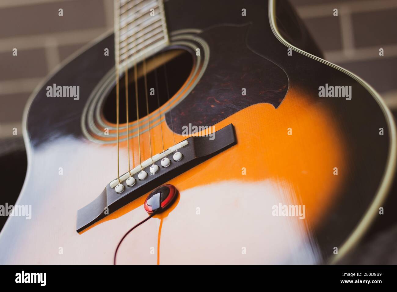 Parte del cuerpo de guitarra acústica con cápsula piezoeléctrica por  caballete y pasadores de puente. La industria de la música, los conceptos  del negocio del entretenimiento Fotografía de stock - Alamy