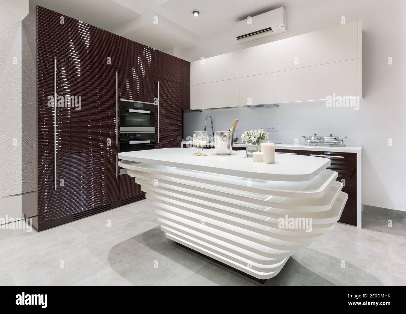 Interior de cocina moderna amueblada con paneles de cara en 3D de cerezo oscuro e isla blanca. Concepto de diseño de cocina Foto de stock