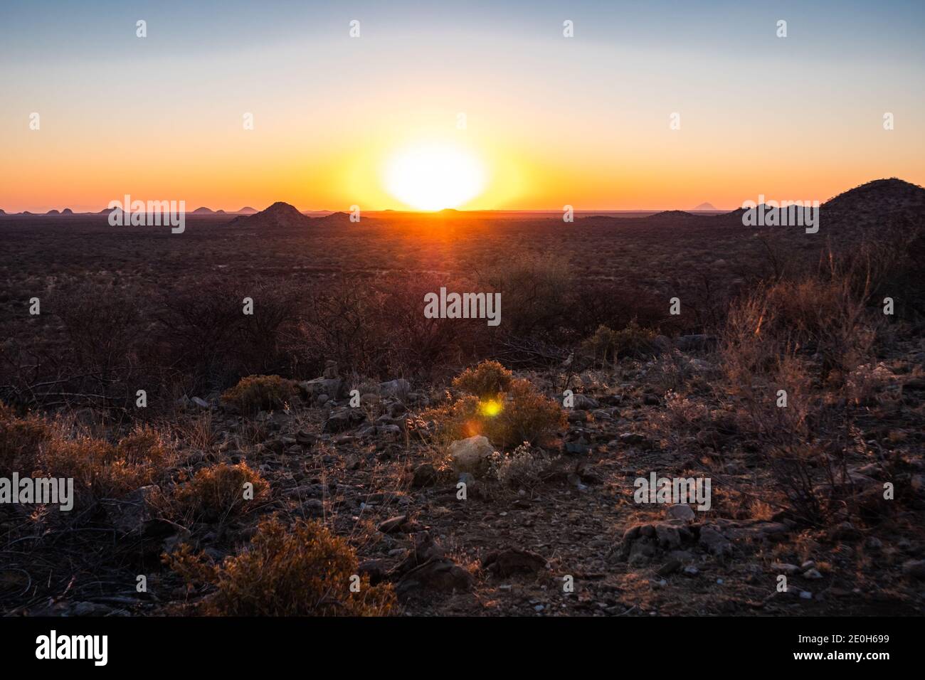Puesta de sol en la sabana en Omaruru, en la región de Erongo, en la meseta central de Namibia, África, puesta de sol escénica en la naturaleza africana Foto de stock