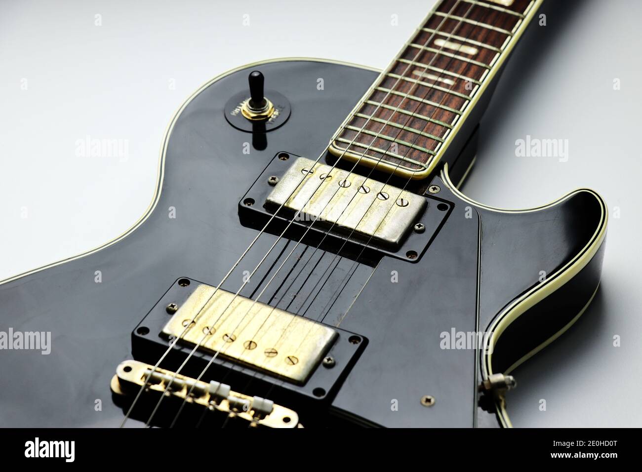 Guitarra eléctrica Les Paul de color negro y dorado con dos humbuckers  sobre fondo blanco - primer plano Fotografía de stock - Alamy
