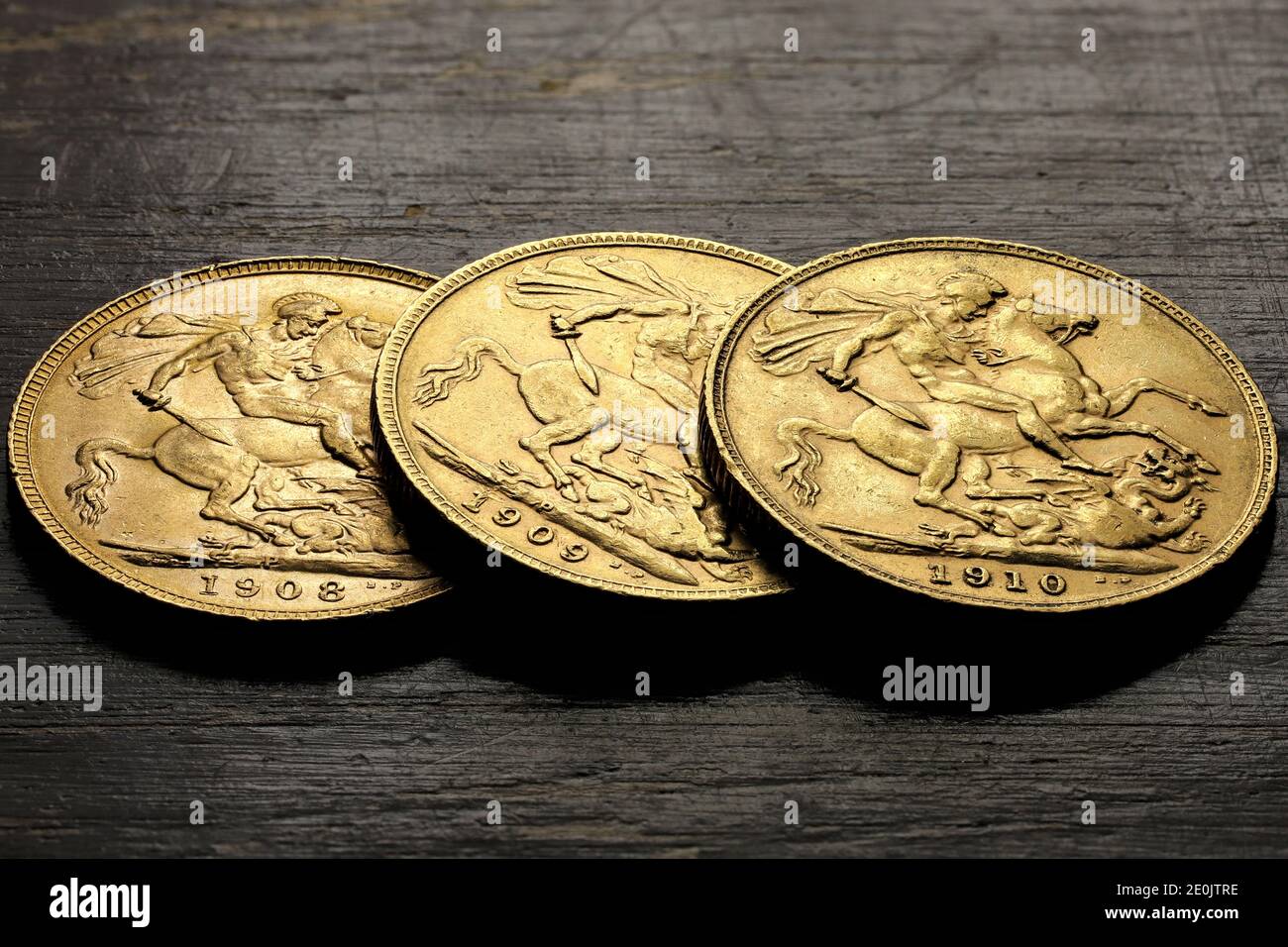 Moneda de oro Soberano (Eduardo VII) sobre fondo rústico de madera Foto de stock