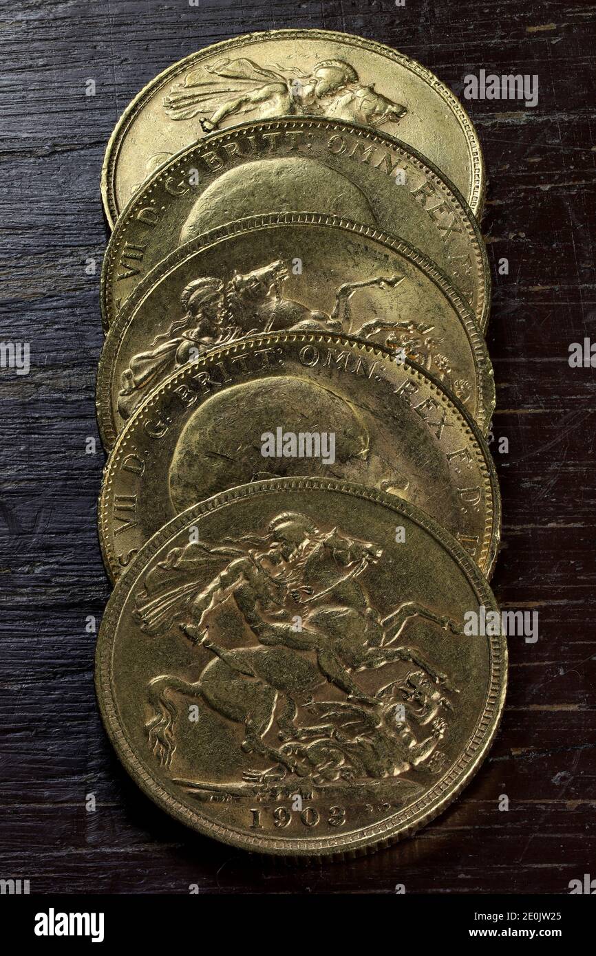 Moneda de oro Soberano (Eduardo VII) sobre fondo rústico de madera Foto de stock