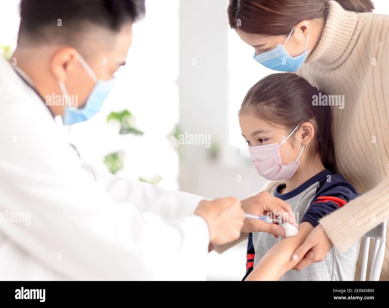 Pediatra examinando a un niño y administrando la inyección. Vacunación contra coronavirus y concepto de vacuna Covid-19 Foto de stock
