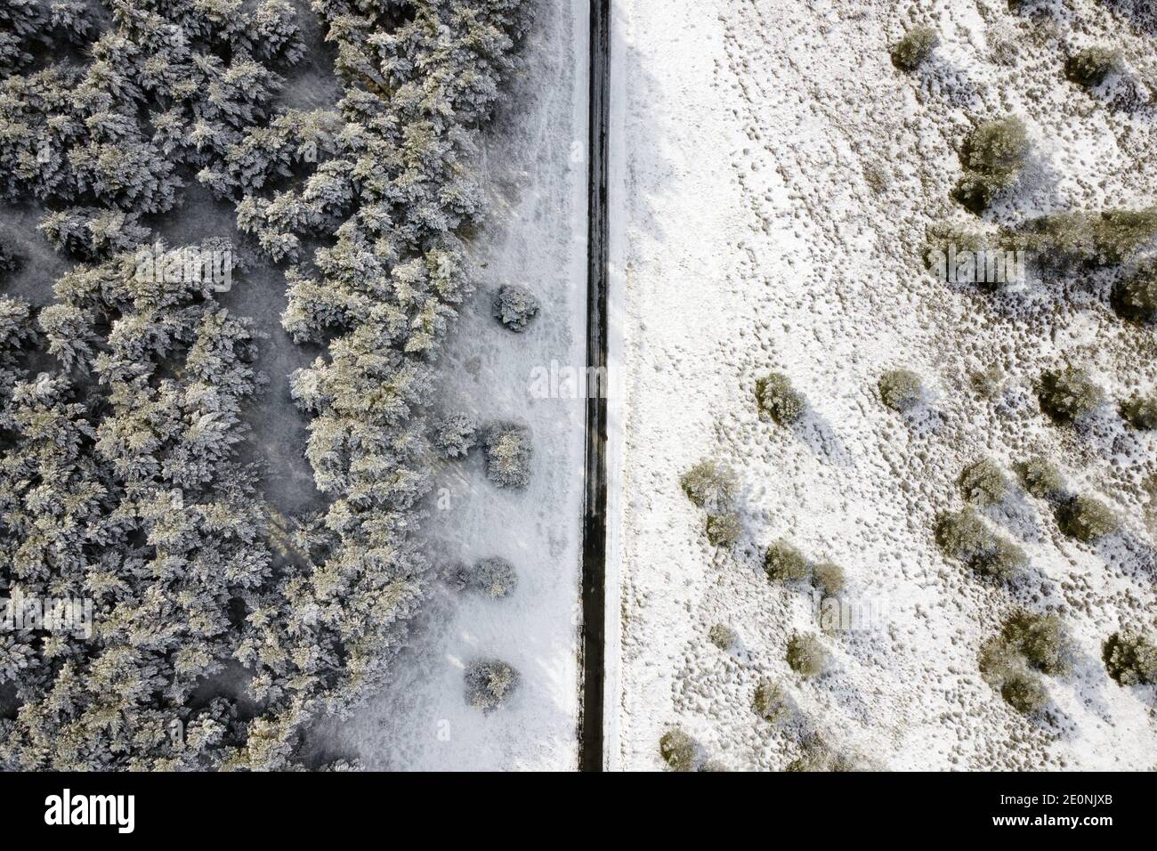Vista aérea de la carretera cubierta de nieve vacía en el bosque de invierno. Foto de alta calidad. Foto de stock