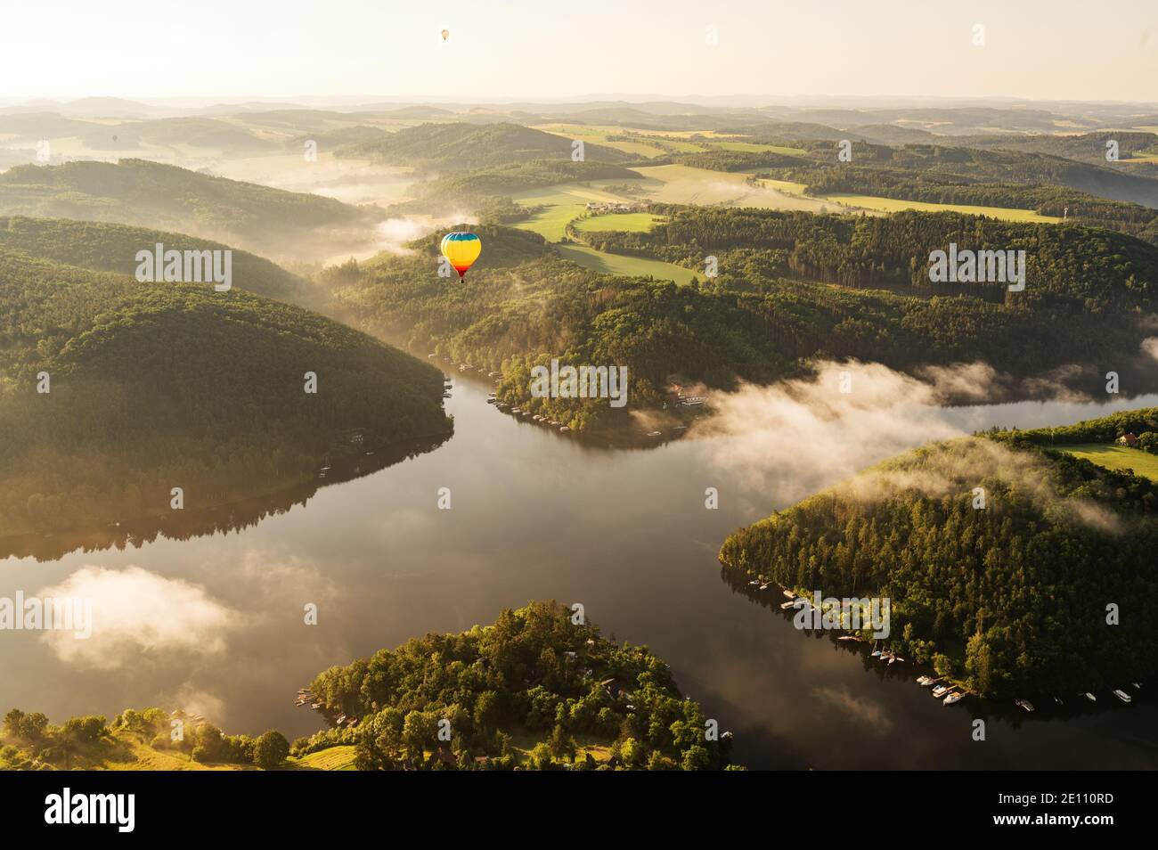 Globo de aire caliente flotando en la luz de la mañana sobre el Paisaje de la República Checa Foto de stock