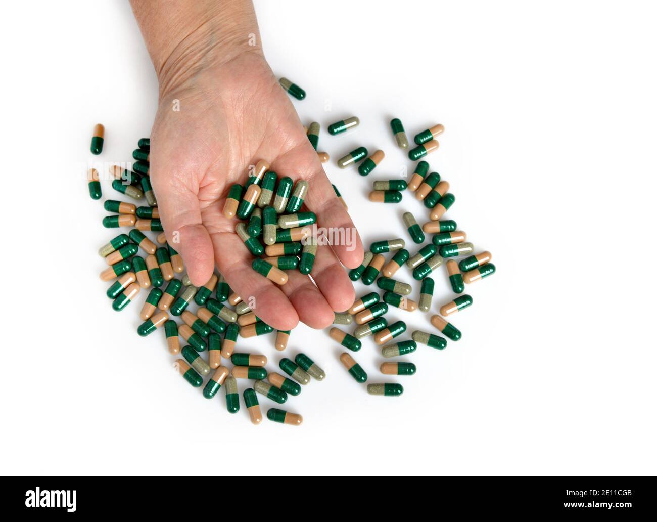 Vitaminas y suplementos. Cierre de la mano sosteniendo variedad de pastillas verdes en la palma. Primer plano de las tabletas de medicación, cápsulas de la mano. Foto de stock