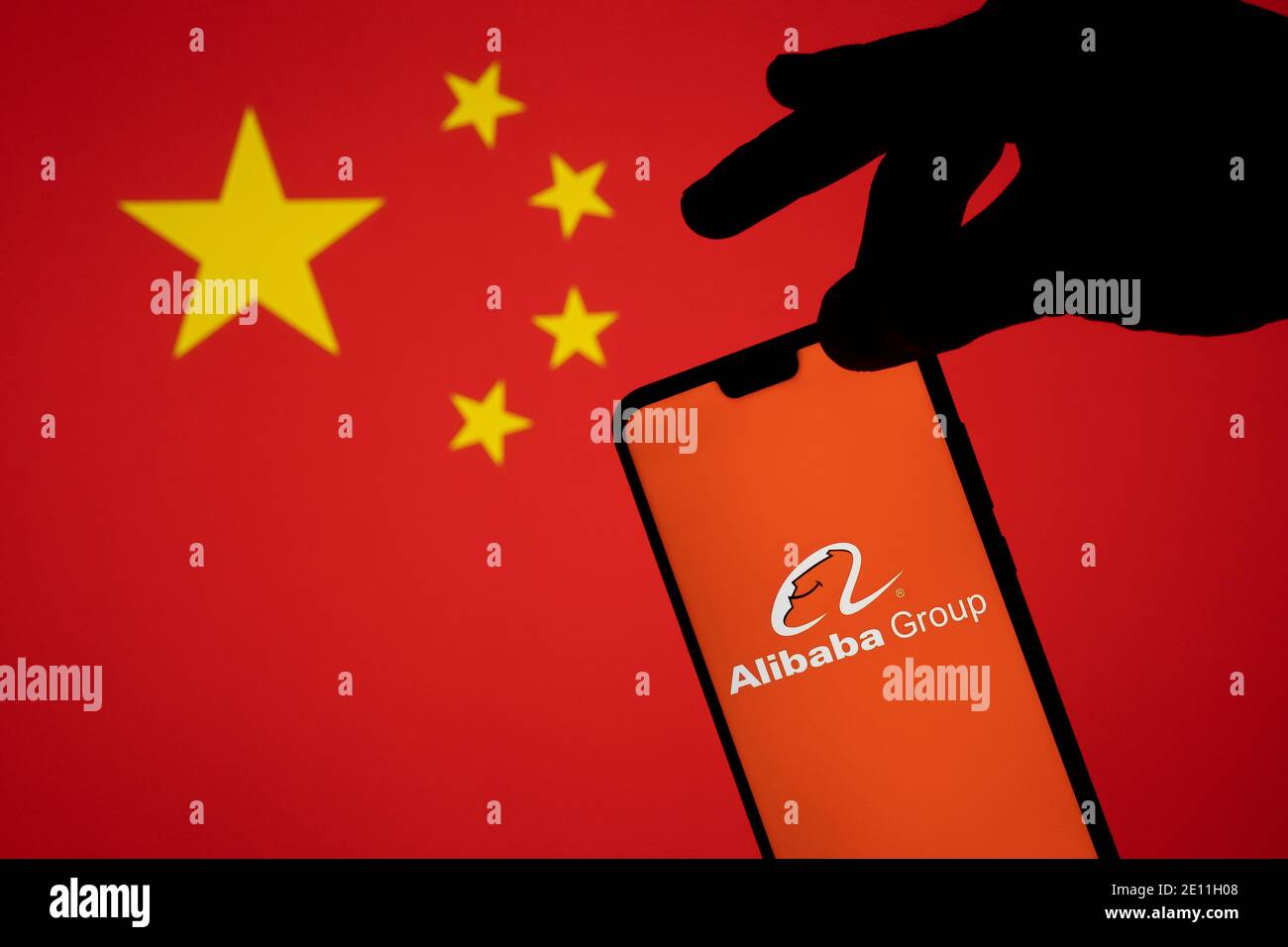 Stafford, Reino Unido - 3 de enero de 2021: Logotipo de Alibaba en una silueta de smartphone que se sostiene en el borde. Concepto para la investigación gubernamental Foto de stock