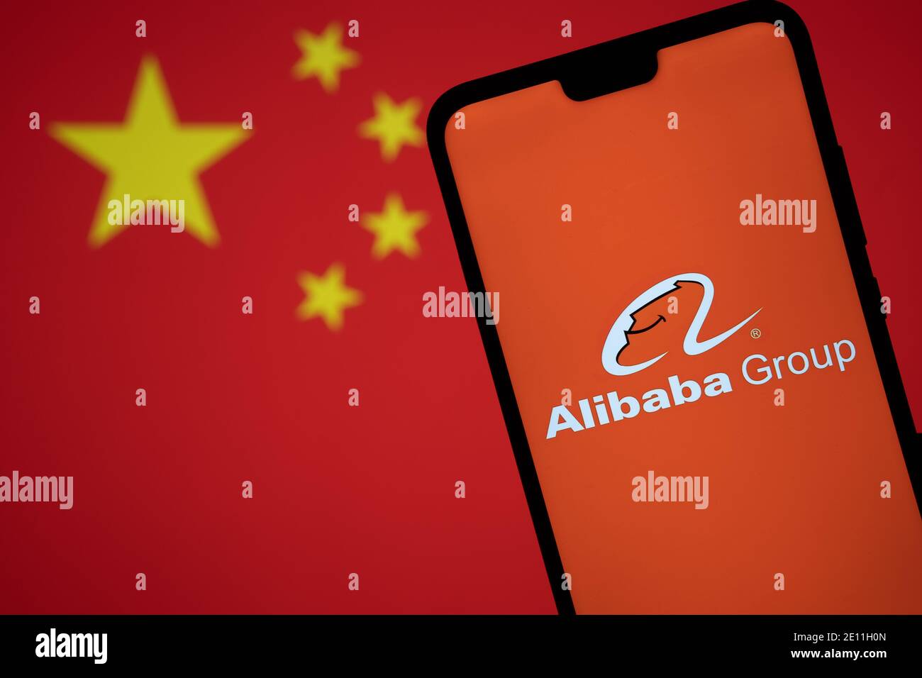 Stafford, Reino Unido - 3 de enero de 2021: Logotipo de Alibaba en una silueta de smartphone y bandera borrosa de China. Concepto para el gobierno y la tecnología g Foto de stock