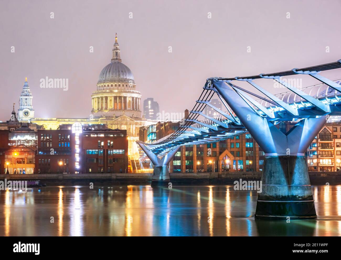Puente del Milenio y la famosa Catedral de San Pablo en el ciudad de Londres iluminada en luces de noche Foto de stock