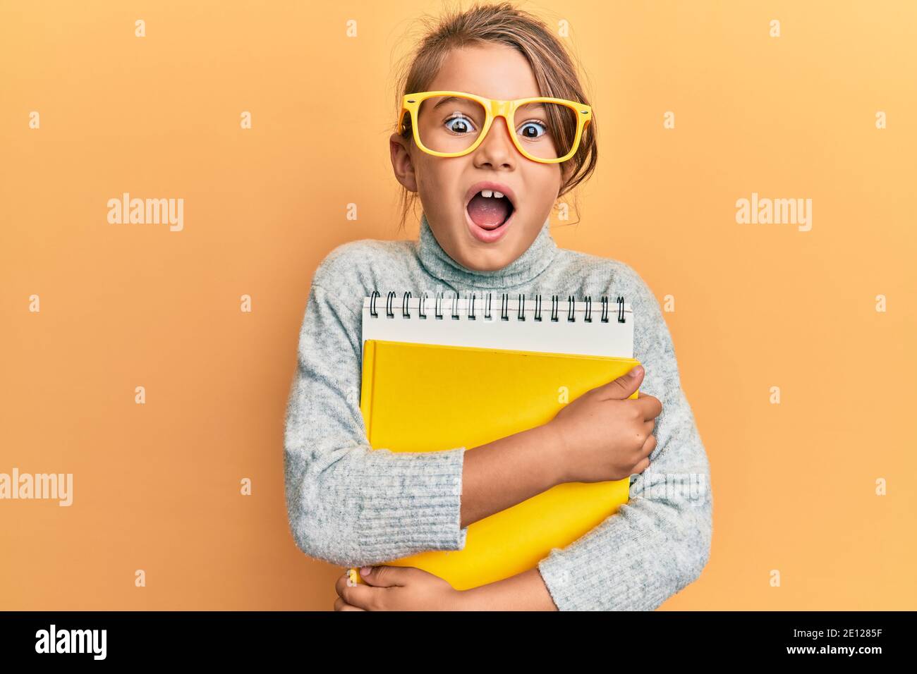 Pequeña hermosa chica con gafas y libros de celebración celebrando loco y  sorprendido por el éxito con los ojos abiertos gritando emocionado  Fotografía de stock - Alamy