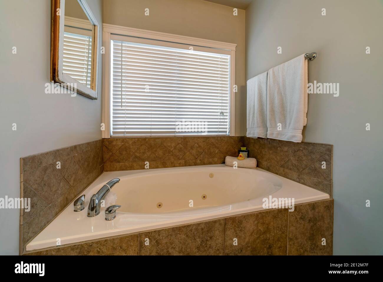 Bañera redonda construida contra la ventana con persianas de baño de una  casa Fotografía de stock - Alamy