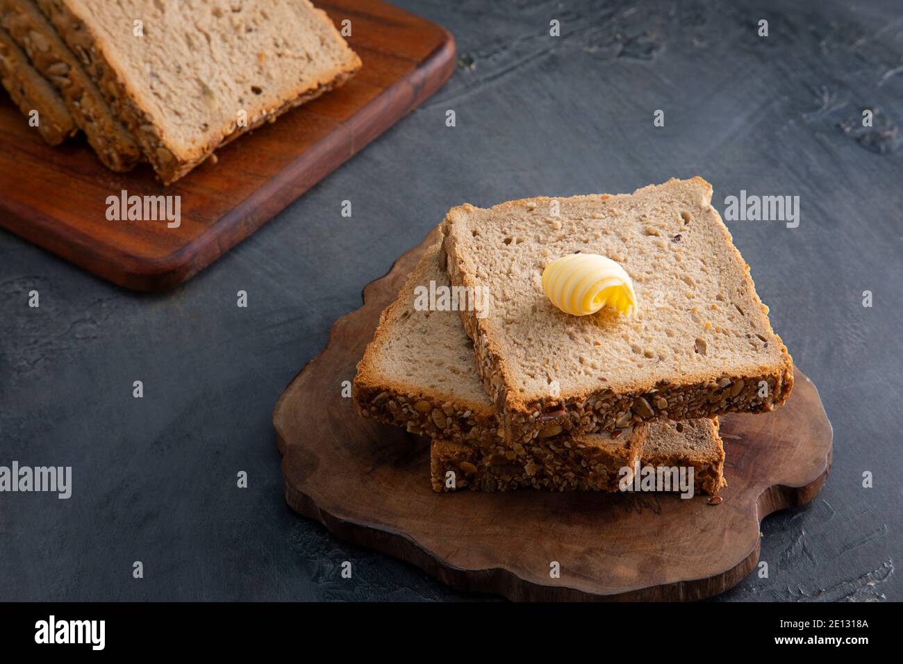 Pan y mantequilla en una mesa negra Foto de stock