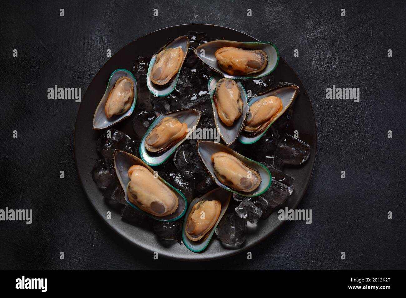 Mariscos mejillones crudos en un plato sobre cubitos de hielo Foto de stock