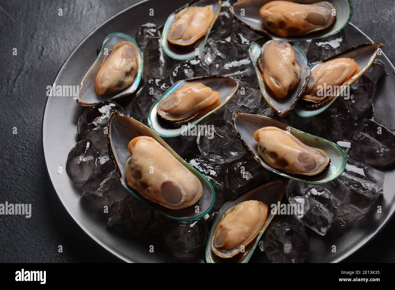 Mariscos mejillones crudos en un plato sobre cubitos de hielo Foto de stock