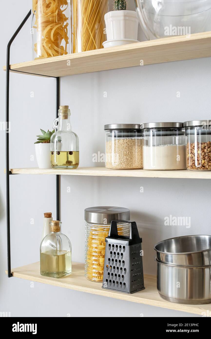 versus cesar utilizar Tarros de vidrio con productos y utensilios de cocina en los estantes  Fotografía de stock - Alamy