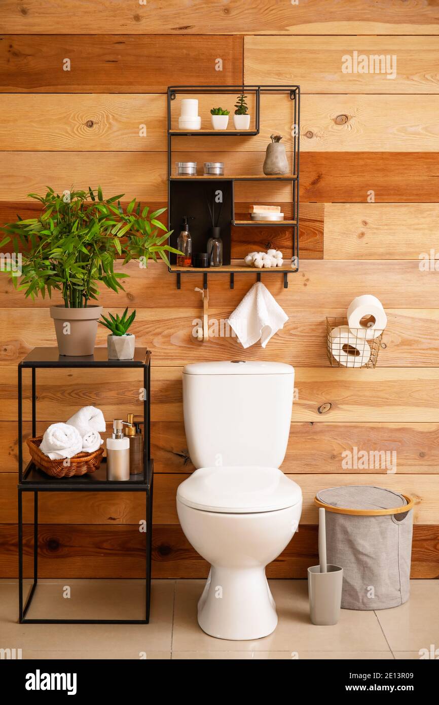 Fregadero con accesorios de baño en la mesa cerca de la pared de madera en  el baño Fotografía de stock - Alamy