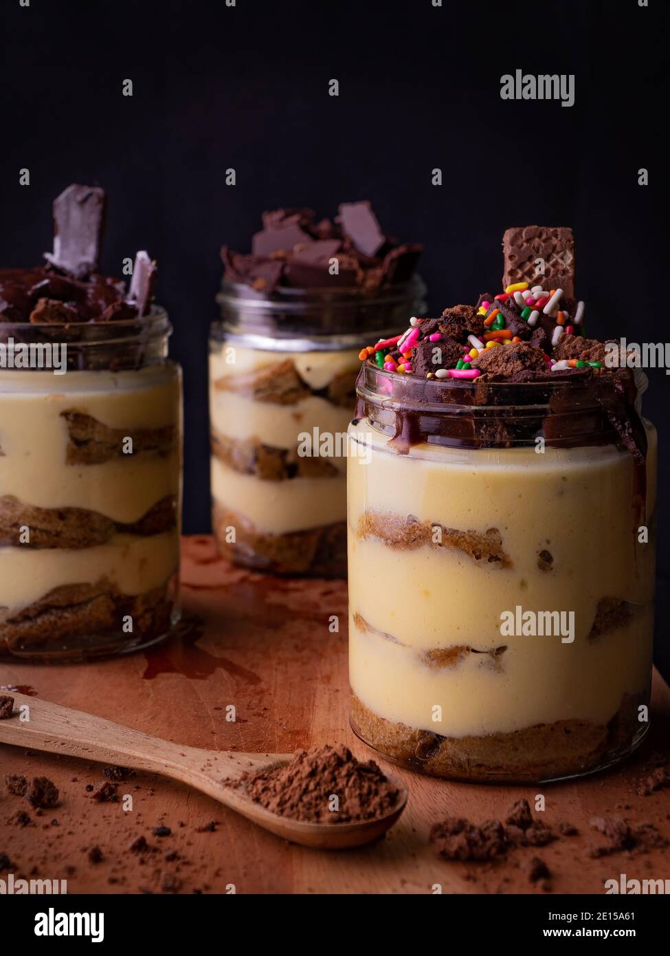 Tiramisu es un postre italiano con sabor a café. Postre tiramisú en tarro con relleno de chocolate y fondo oscuro Foto de stock