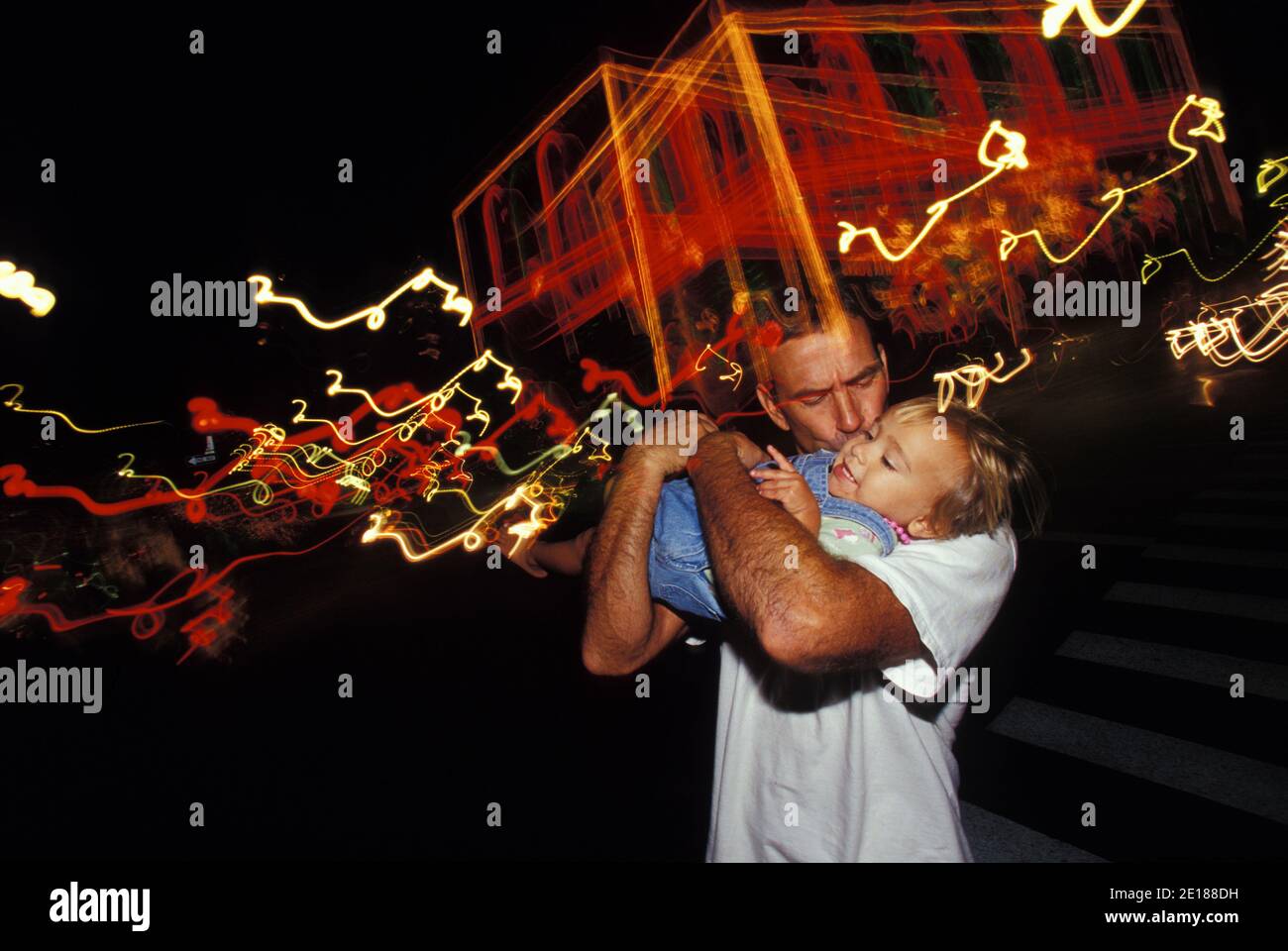 El padre besa a la hija cerca de las luces de Navidad en el centro de Honolulu Foto de stock