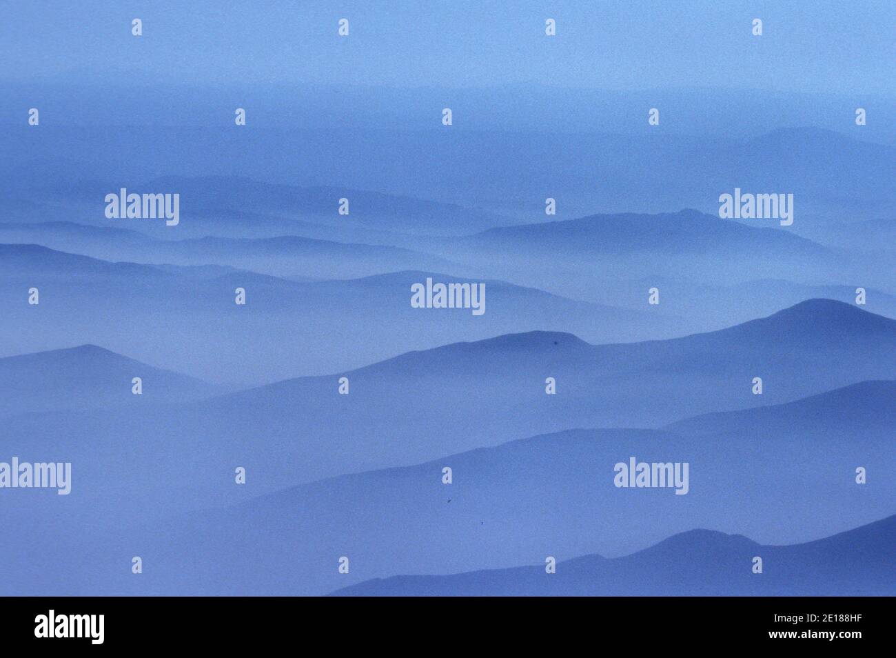 Misty nubes blancas por la mañana con crestas de montaña Foto de stock
