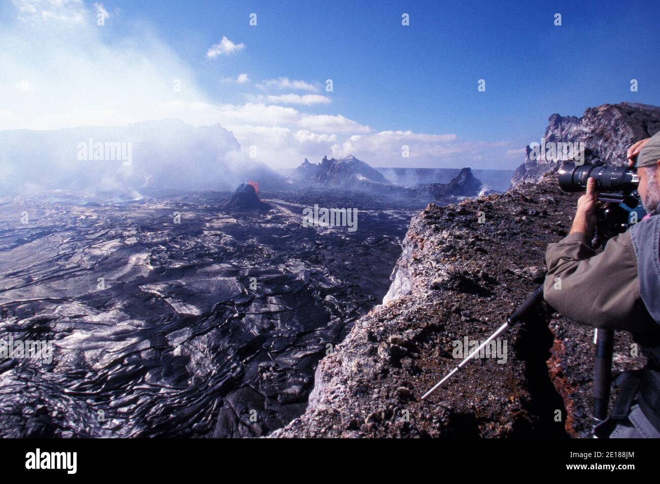 El veterano fotógrafo del volcán Brad Lewis filmando la erupción de Pu' o'o Caldera, Parque Nacional de los Volcanes Foto de stock