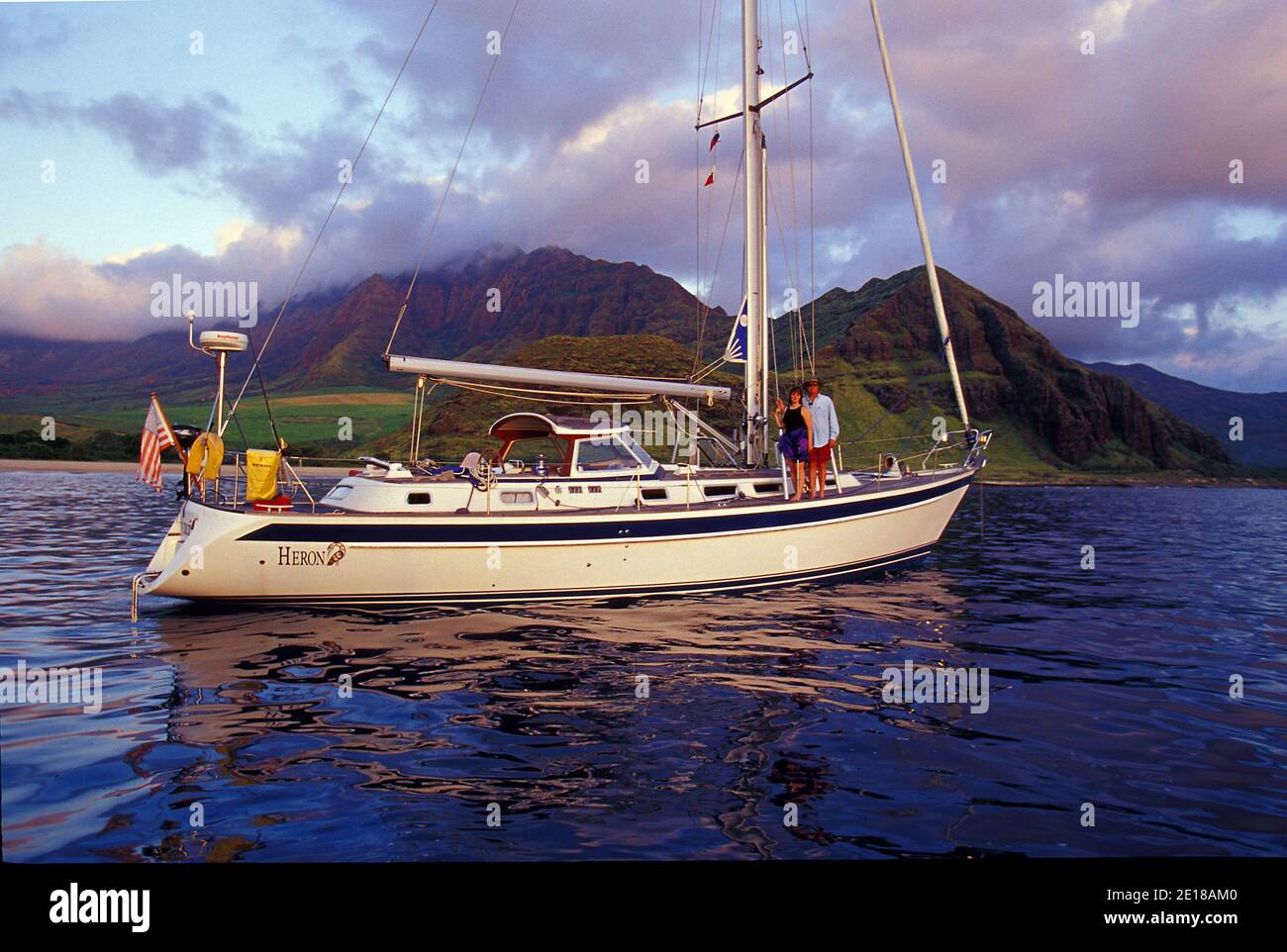Couple on deck of their 48 foot sailboat off Makua Beach, West Oahu, Hawaii Foto de stock
