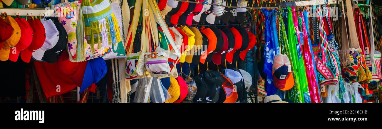 Una colorida tienda de la calle que muestra un montón de objetos organizados, sombreros y ropa Foto de stock
