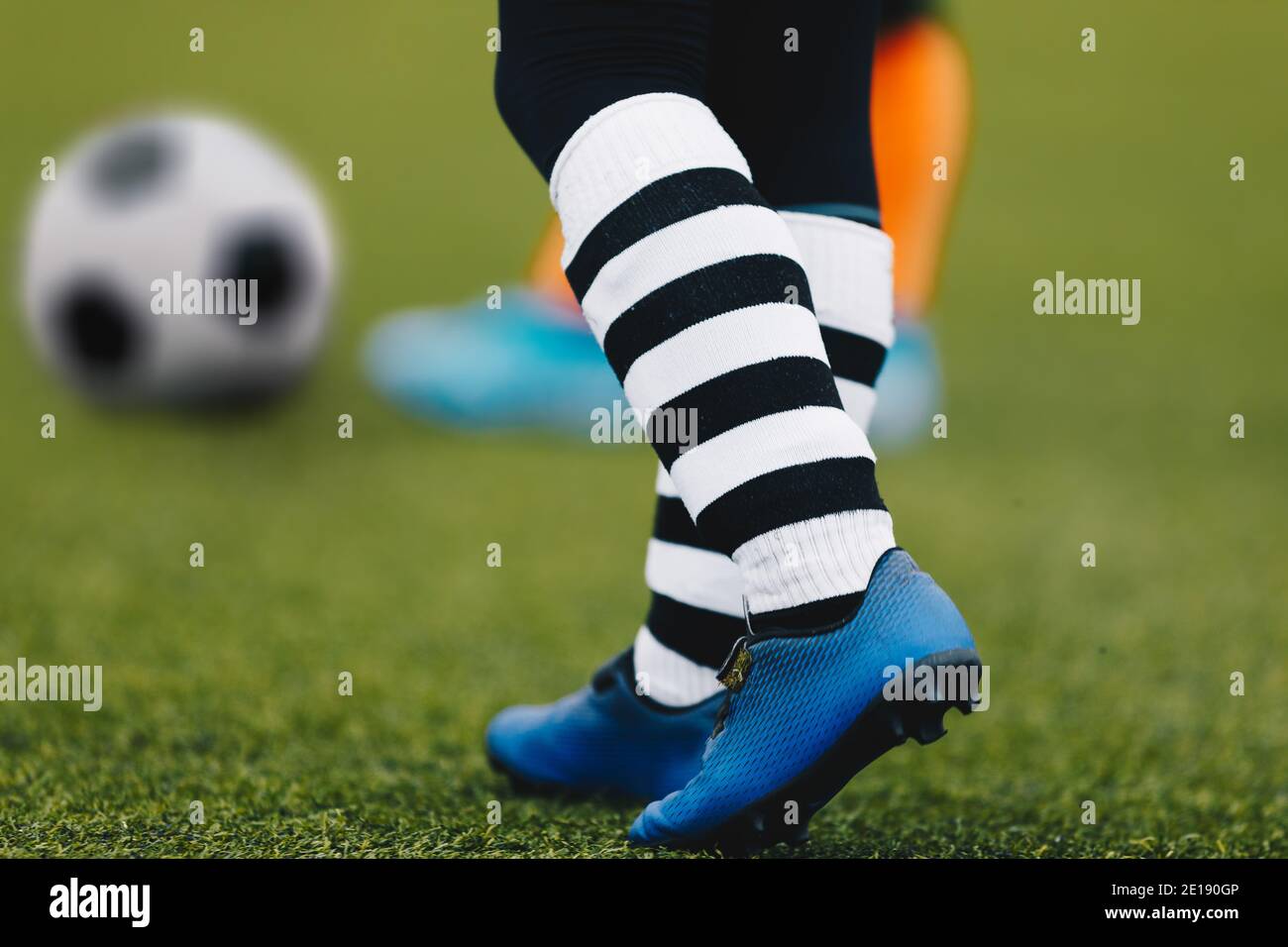 Jugador de fútbol en botas. Soccer Boy está caminando sobre hierba. Equipo  de futbolistas. Pelota de fútbol en el fondo difuminado Fotografía de stock  - Alamy