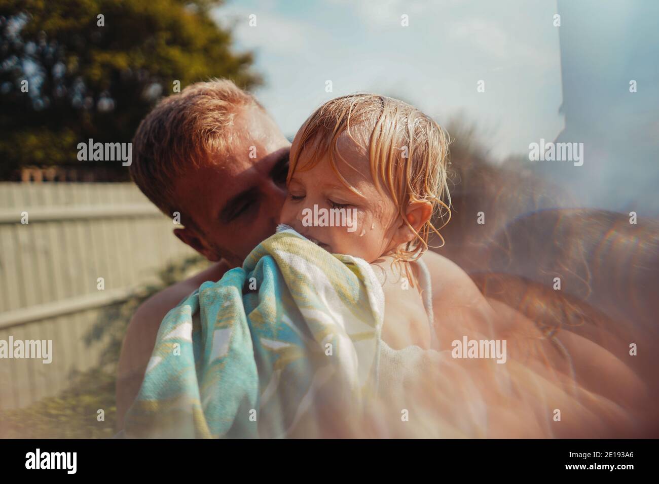 Niño jugando con un rociador en el jardín Foto de stock