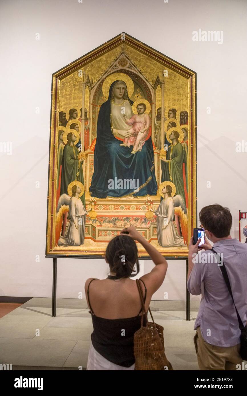 Italia, Toscana: Florencia (Florencia en italiano). El Ognissanti Madonna, una pintura de Giotto di Bondone en la Galería Uffizi. Visitantes tomando un pictur Foto de stock