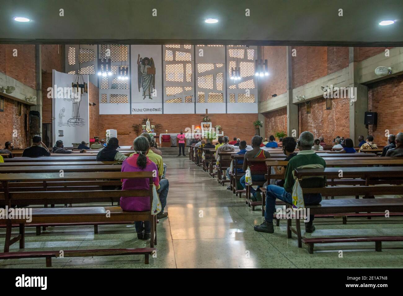 La gente espera dentro de los terrenos de la iglesia para ser llamado por  su número y poder recoger su olla de comida. El bote solidario es un  programa social Fotografía de