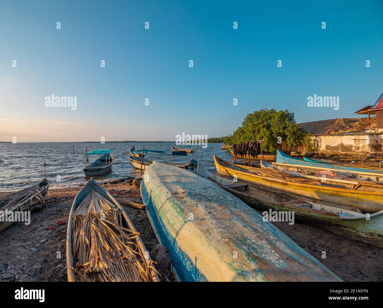 Un grupo de coloridos barcos rústicos están descansando sobre un playa justo después de actividades de pesca Foto de stock