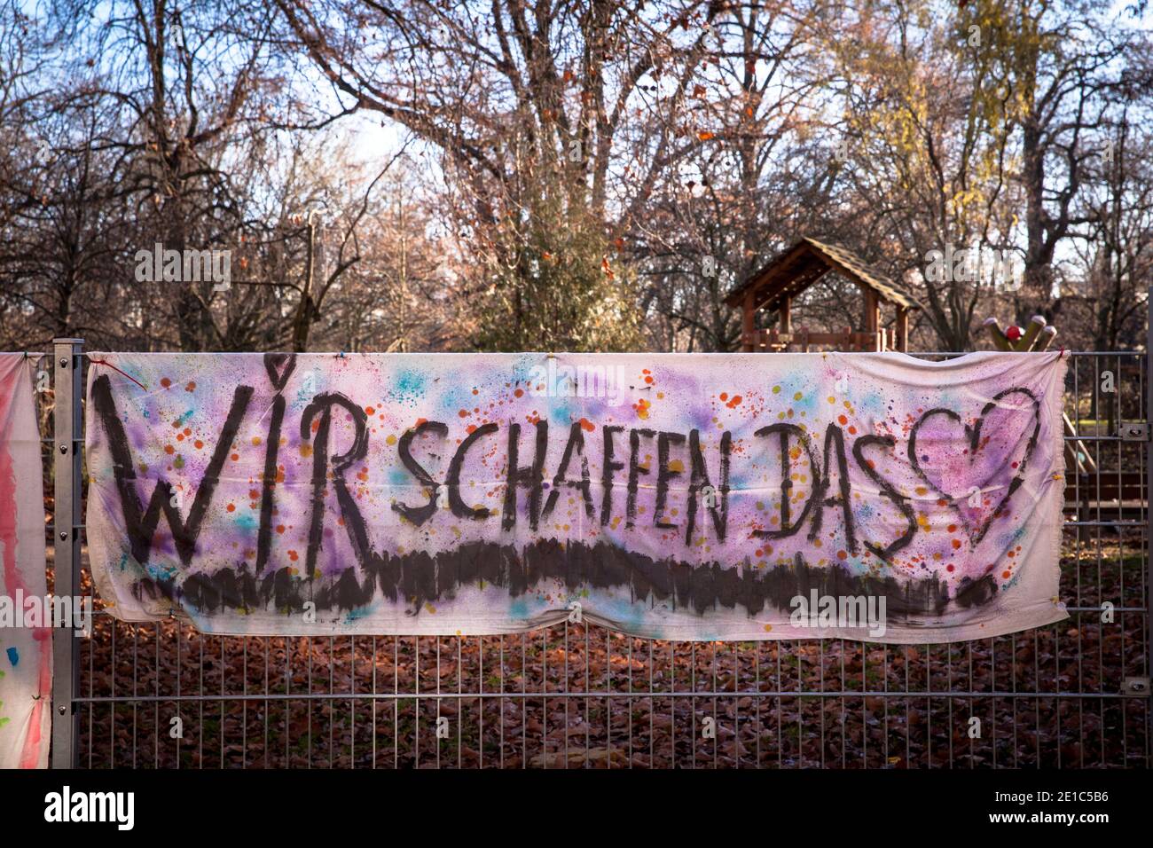 Pancartas pintadas por niños cuelgan en la valla de un jardín de infantes en el distrito Neustadt-Sued durante la pandemia de Corona, traducción: Podemos hacerlo. C Foto de stock