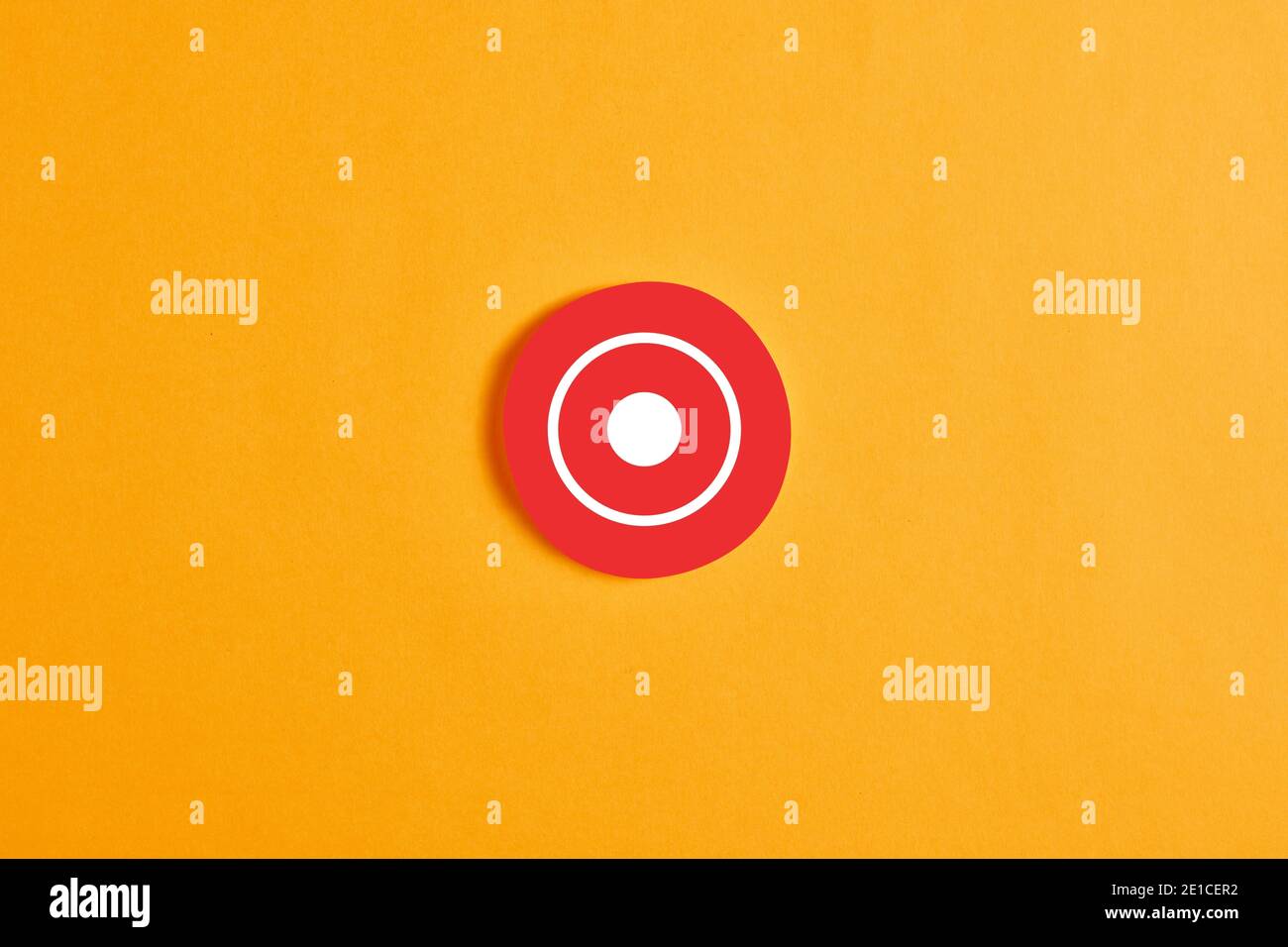 Círculo rojo redondo con un botón de grabación (rec) o icono sobre fondo amarillo. Foto de stock