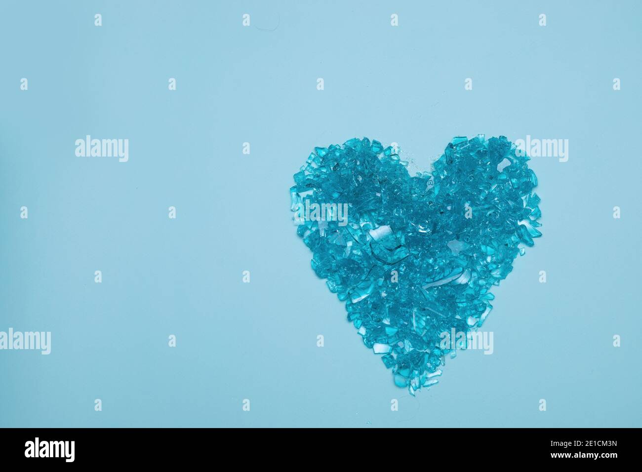 Corazón de cristal roto sobre fondo azul. Concepto de corazón roto hecho de fragmentos. Día de San Valentín Foto de stock
