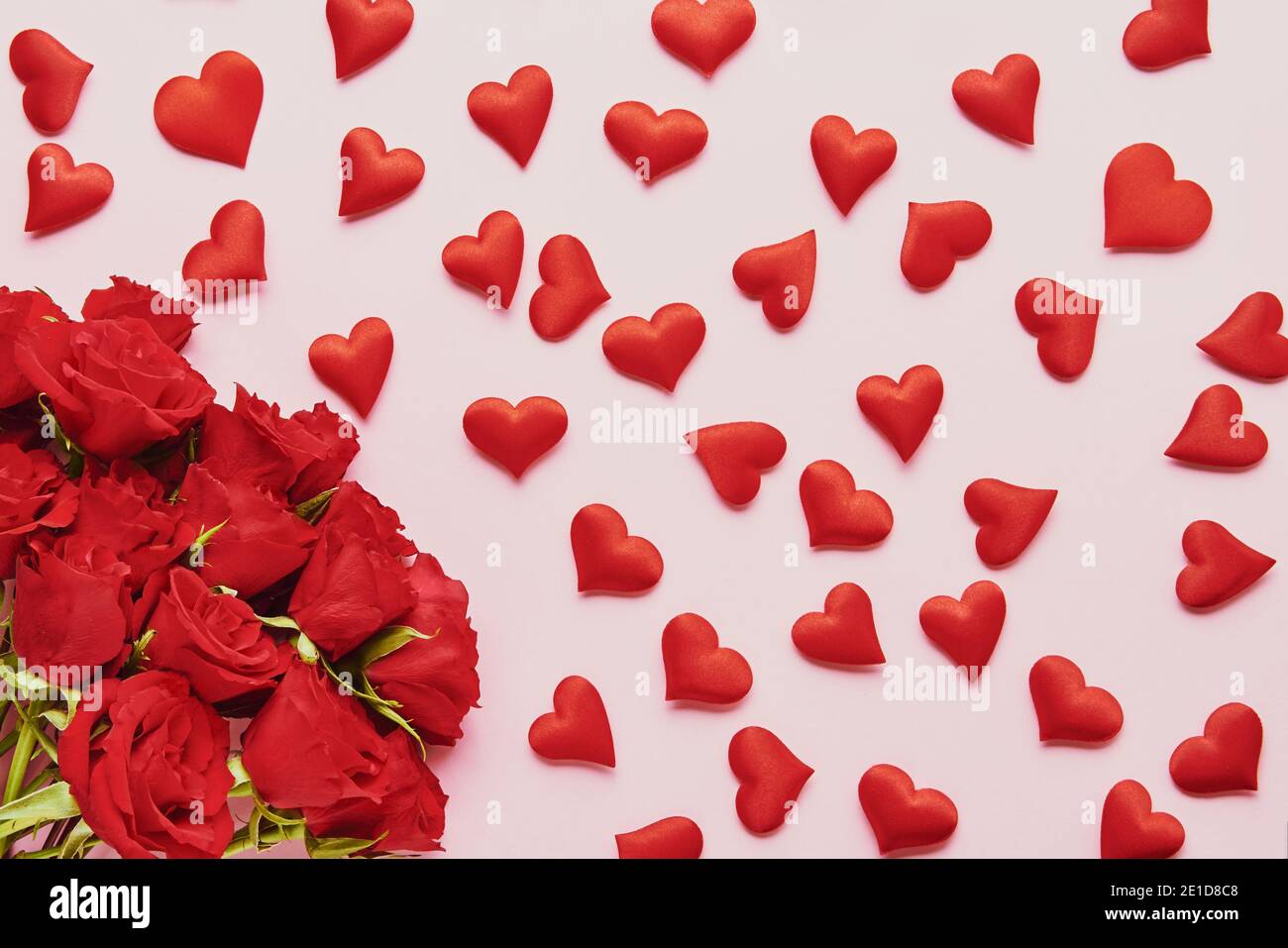 Concepto del día de San Valentín. Corazones rojos y rosas rojas ramo de flores sobre un fondo rosa. Lay plano. Foto de stock