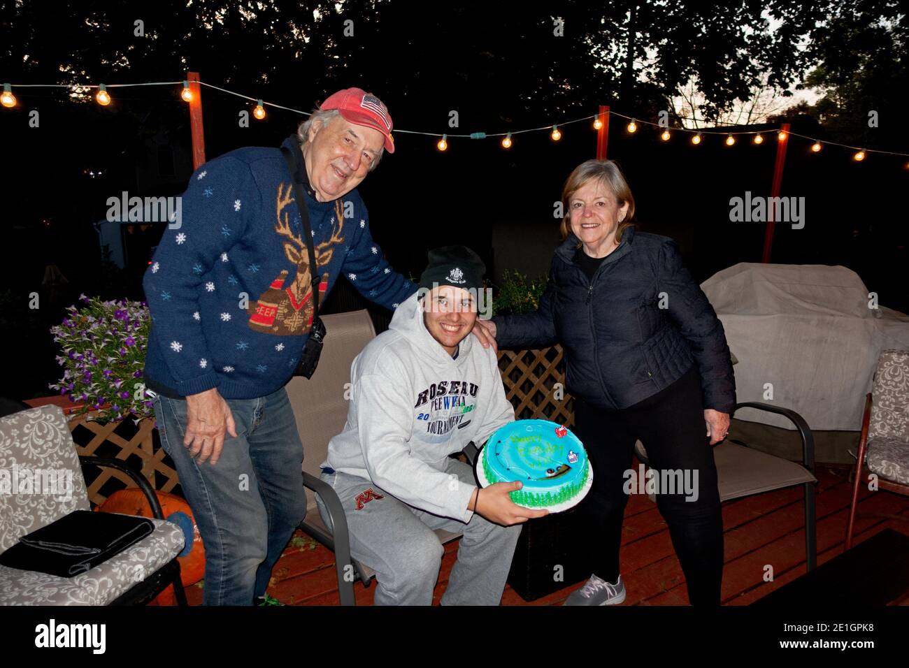 Nieto de 18 años con abuelos celebrando con pastel de cumpleaños durante Covid Pandemic tratando de mantener una distancia social. St Paul Minnesota MN EE.UU Foto de stock