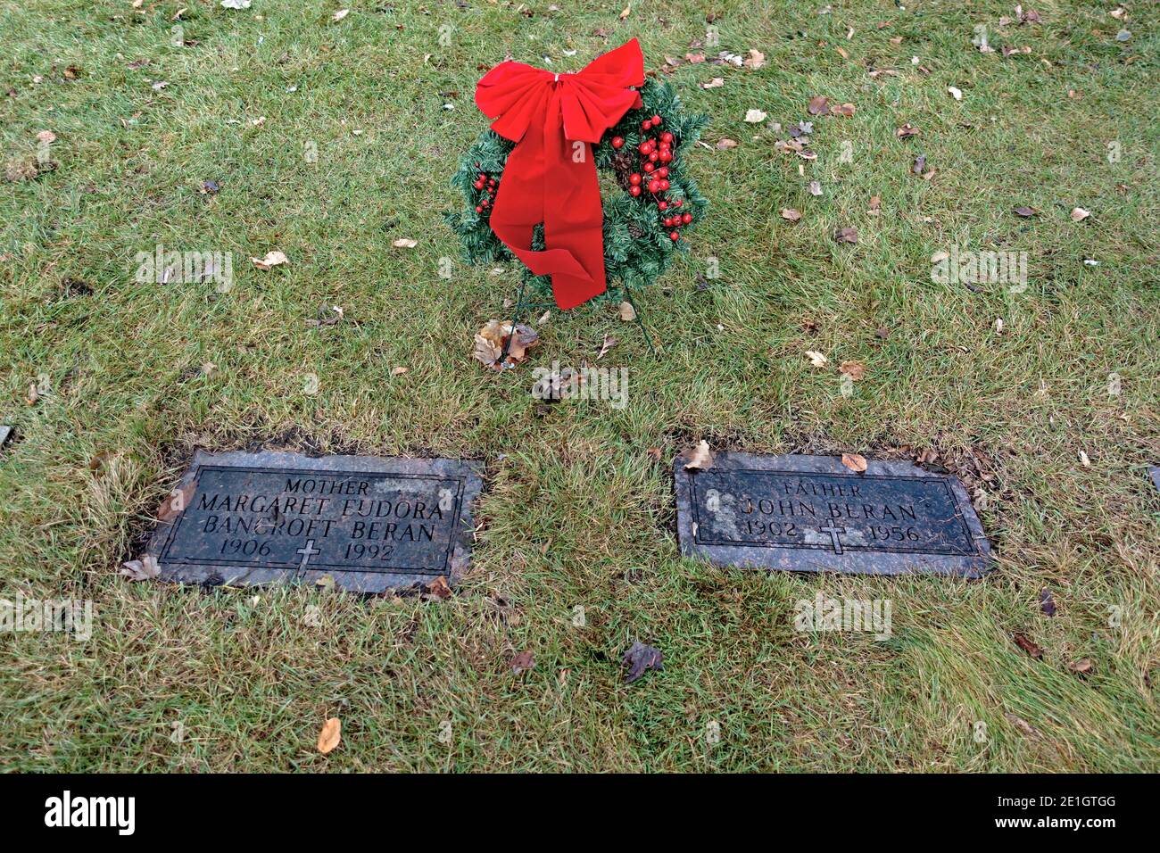 Corona de Navidad decorada con un arco rojo en el cementerio para la tumba de los padres. Minneapolis Minnesota MN EE.UU Foto de stock